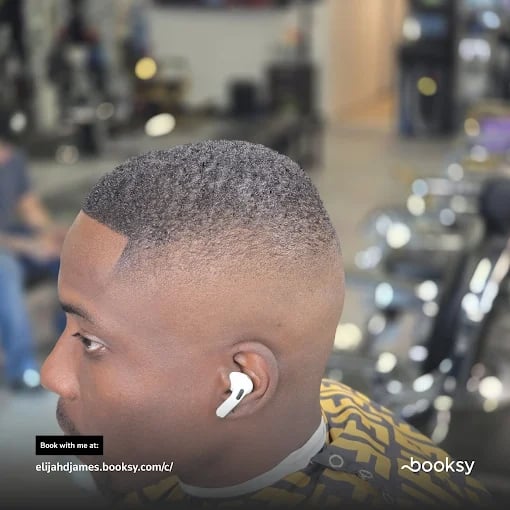 Fade haircut side profile with AirPods in barbershop setting