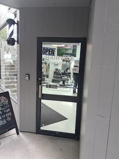 Glass door with "Open" sign and business hours at storefront entrance