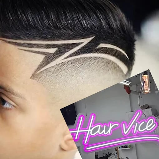 Intricate hair design with geometric fade and sharp lines at salon